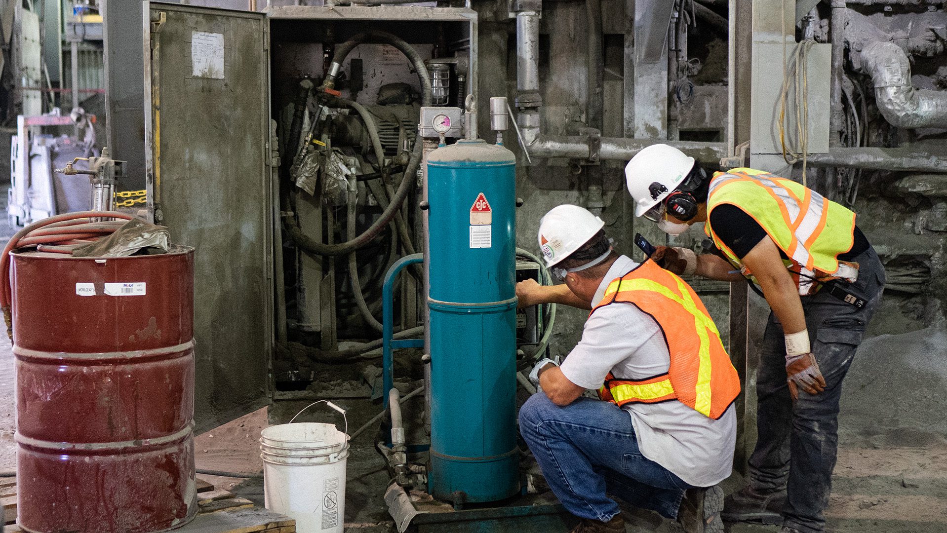 LaFarge 2022 Two men look into an electrical box, blue CJC filter sits in the foreground.